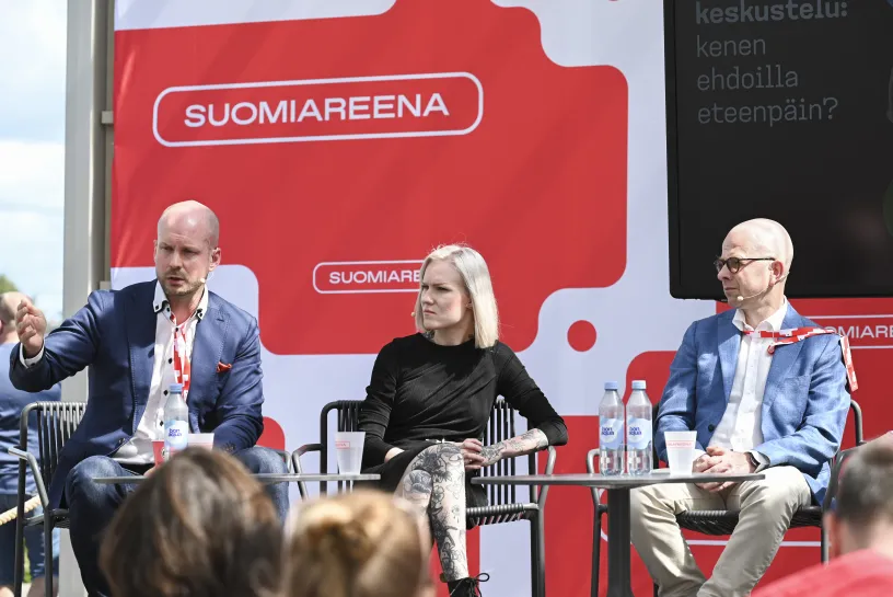 Keskustelupaneelissa ulkona, taustalla SUOMIAREENA-logo.