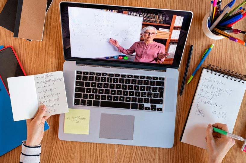 opiskelija tekee muistiinpanoja tietokoneen näytöllä opettaja