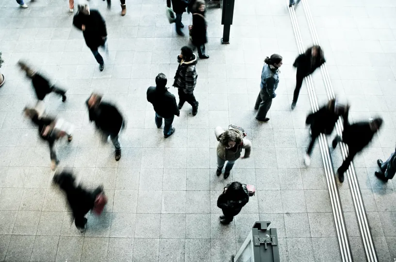 Kuvituskuva lintuperspektiivistä kuvattuja ihmisiä metroasemalla kävelemässä