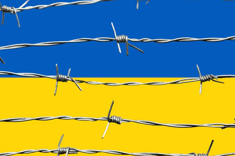 ukrainan lippu piikkilanka-aidan takana