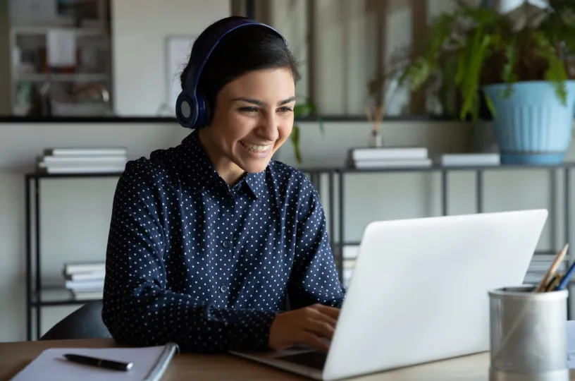 Nainen osallistuu webinaariin tietokoneella. 