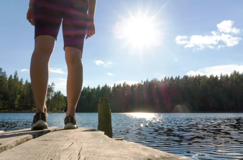 nainen laiturilla suomalaisessa kesämaisemassa