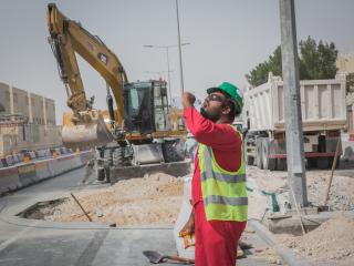 Rakennusmies juo vettä qatarilaisella työmaalla, 