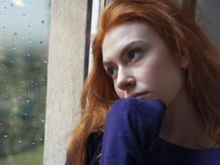 Nuori nainen katsoo synkkänä ulos ikkunasta