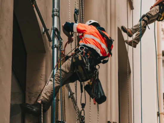 Henkilö kipuaa ylös köydellä