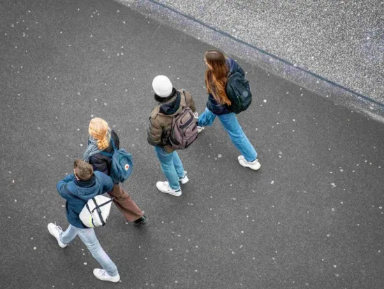 Opiskelijat kävelevät kadulla