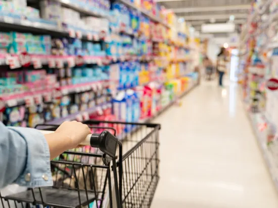 Henkilö työntää kaupassa kärryjä