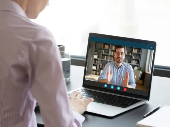 Nainen osallistuu webinaariin tietokoneella.