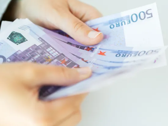 Nainen pitää suuria seteleitä, raha ja talous