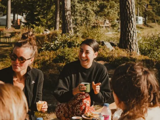 Ihmiset nauravat leirinuotiolla