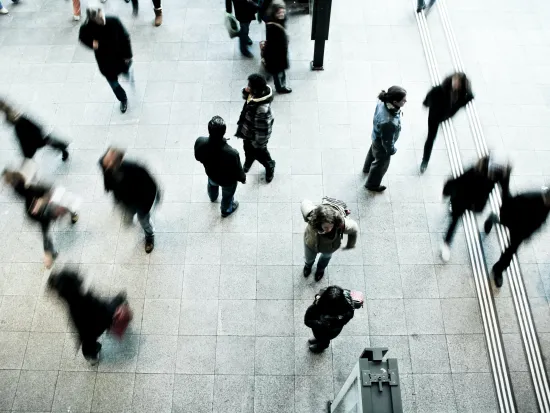 Kuvituskuva lintuperspektiivistä kuvattuja ihmisiä metroasemalla kävelemässä