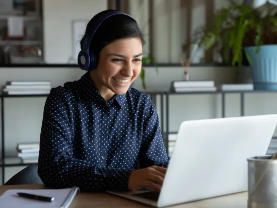 Nainen osallistuu webinaariin tietokoneella. 