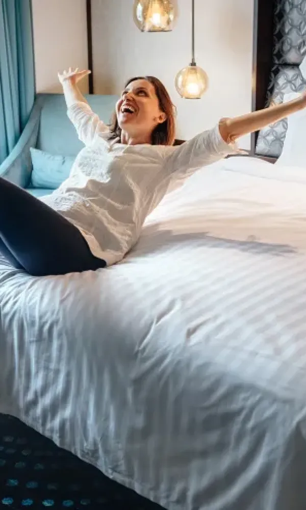 Nainen kaatumassa sängylle