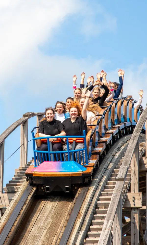 Ihmisiä vuoristoradan vaunun kyydissä