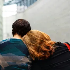 Kaksi ihmistä nojaa toisiinsa