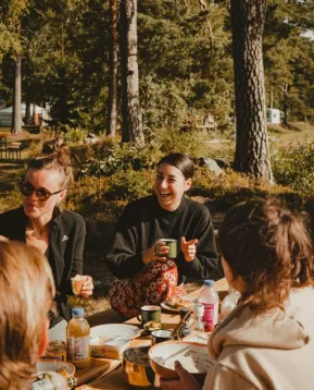 Ihmiset nauravat leirinuotiolla